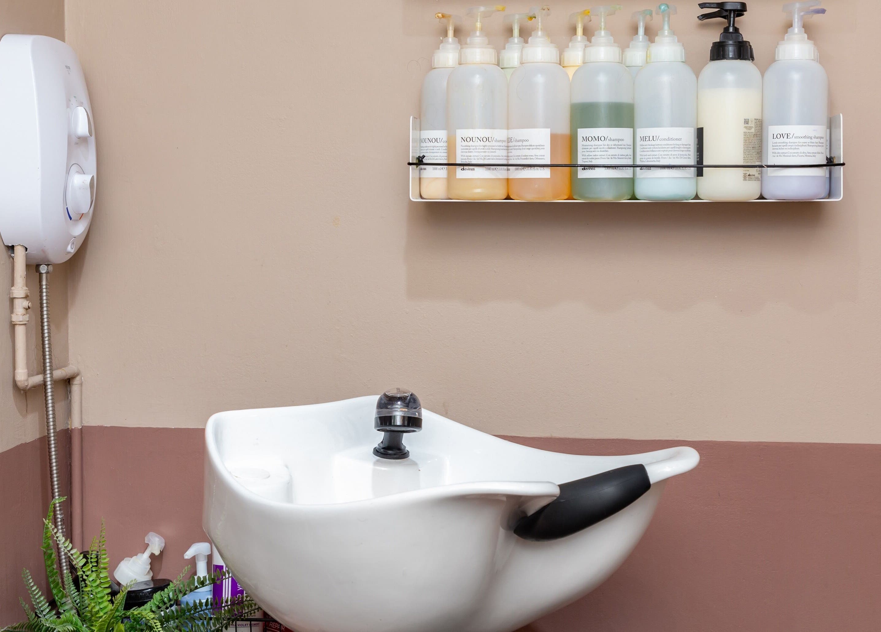 Modern hair wash station with products at De.Salons Peckham, London, England, GB.