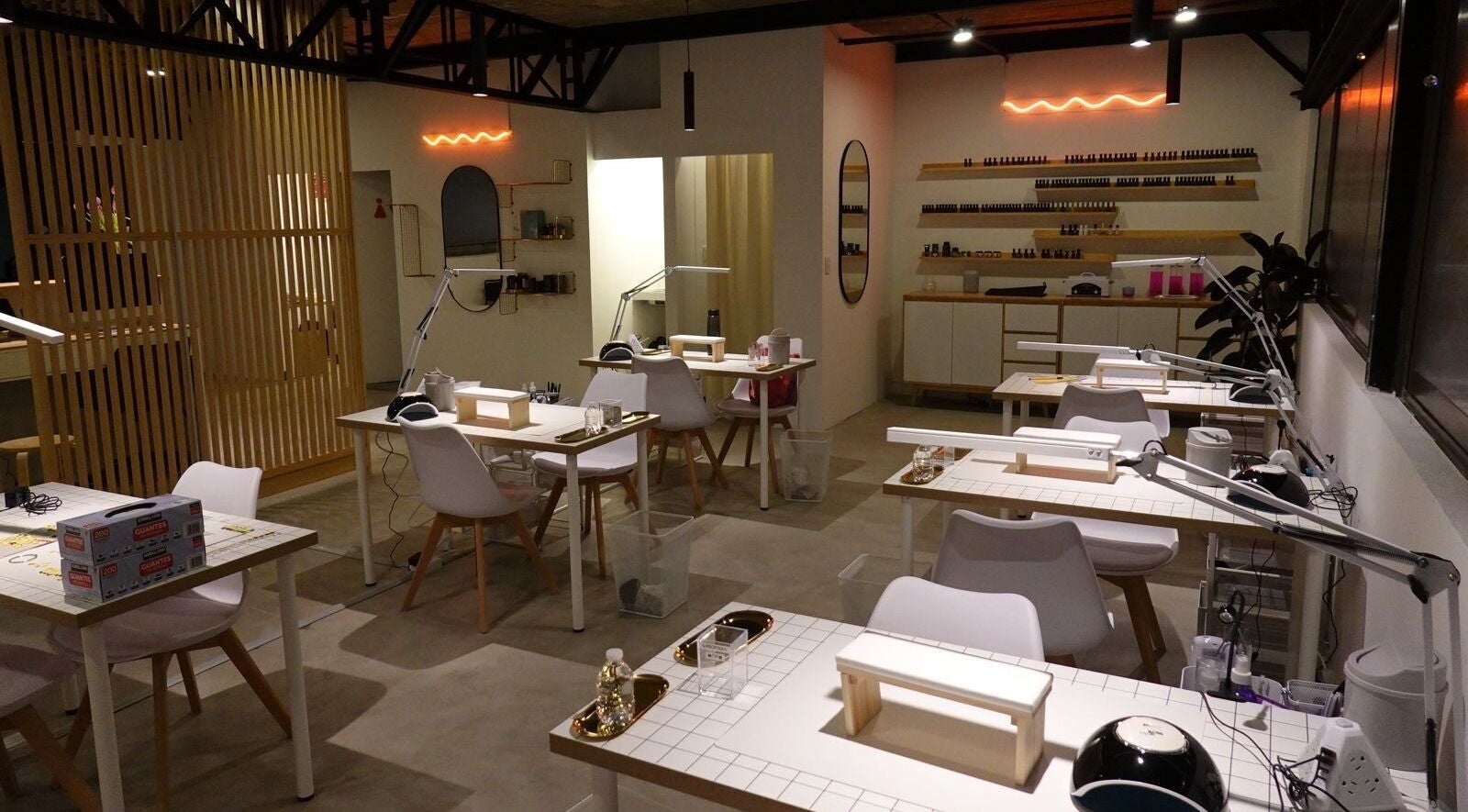 Interior moderno de Hi Hi Nails Roma en Ciudad De México, MX, con estaciones de manicura bien iluminadas.