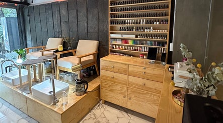 Rincón acogedor en Hi Hi Nails Roma, Ciudad De México, MX, con sillas confortables y esmaltes exhibidos.