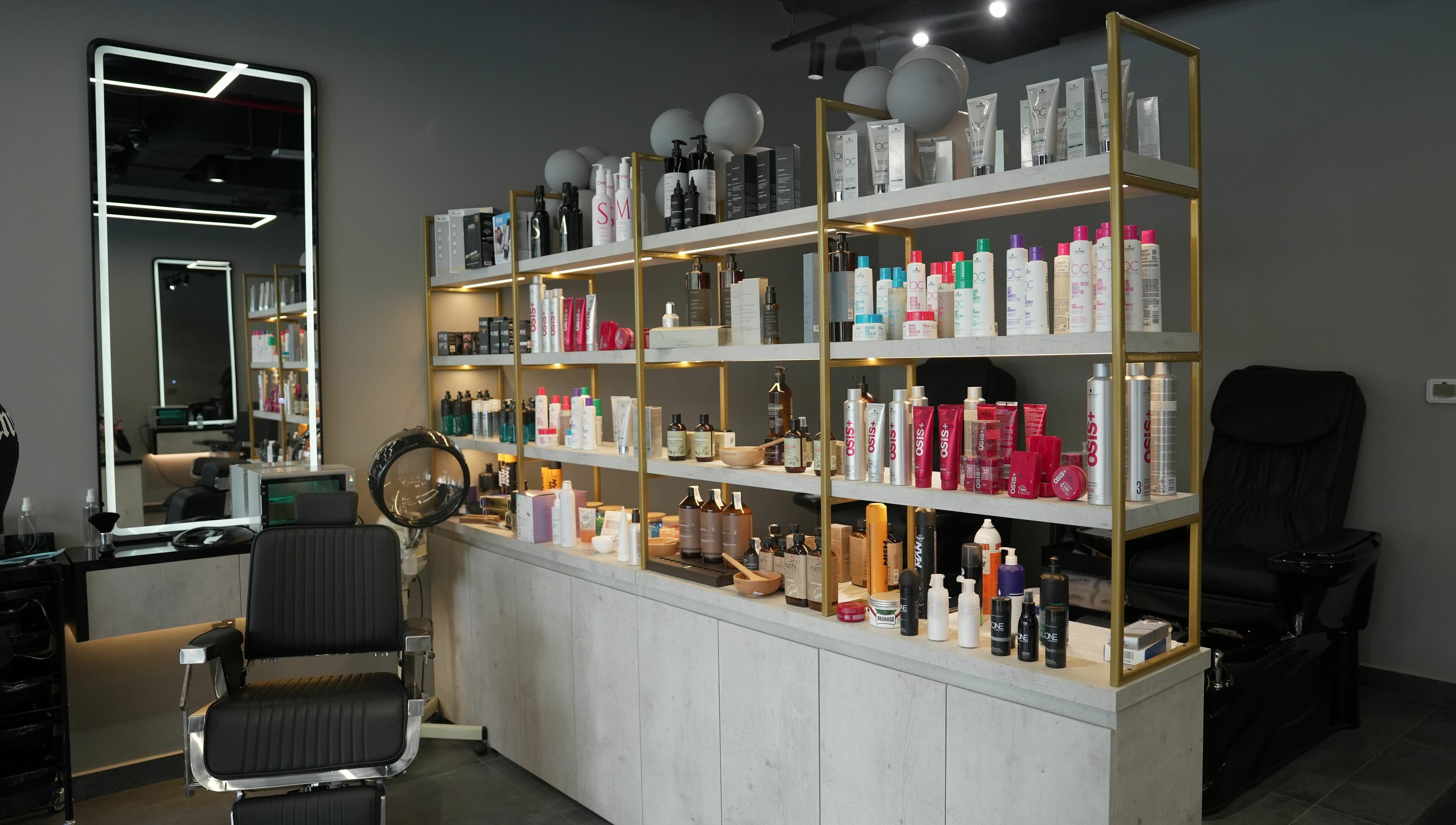 Product shelves and styling chair at Abroshka Gents Salon, Dubai, AE, showcasing salon essentials.