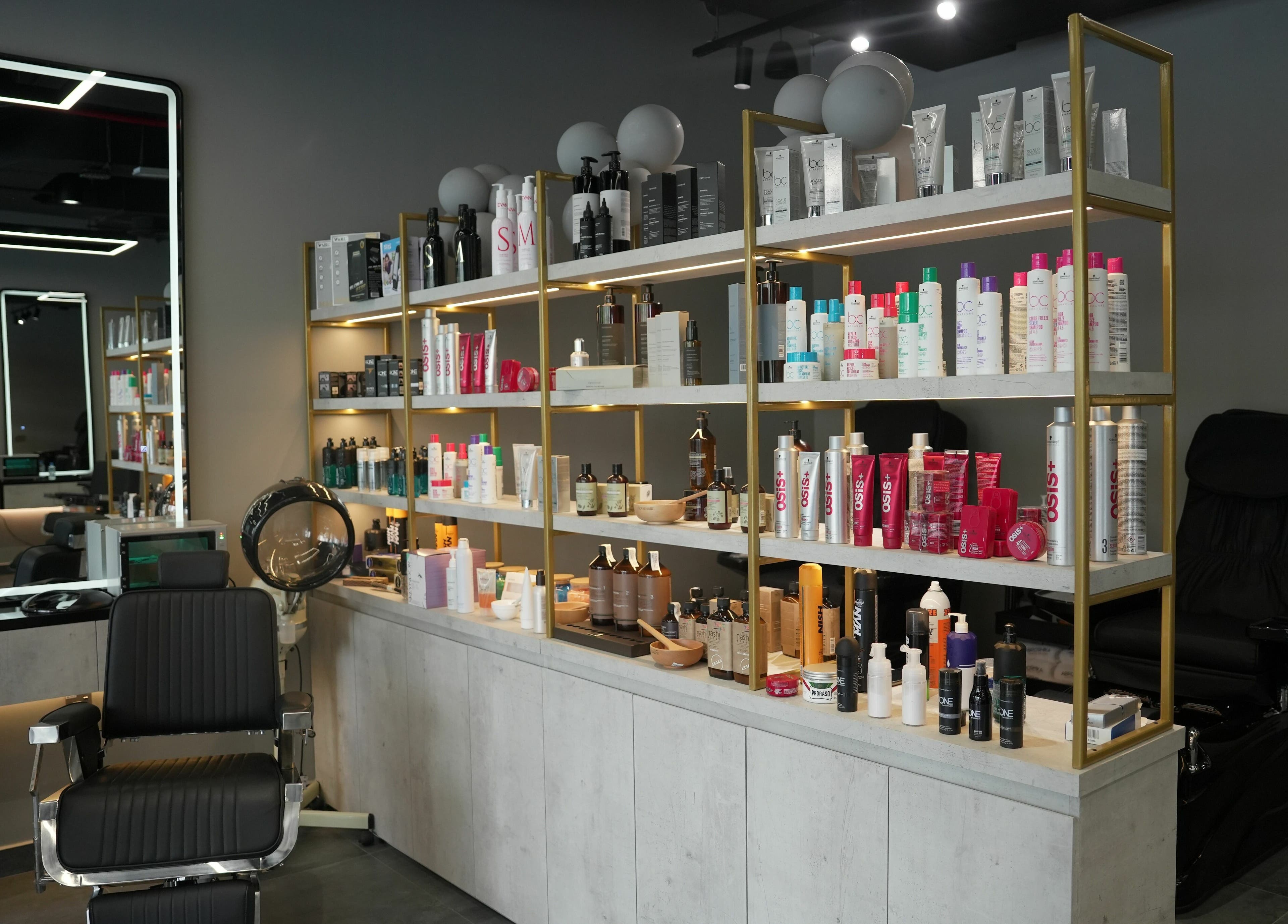 Product shelves and styling chair at Abroshka Gents Salon, Dubai, AE, showcasing salon essentials.