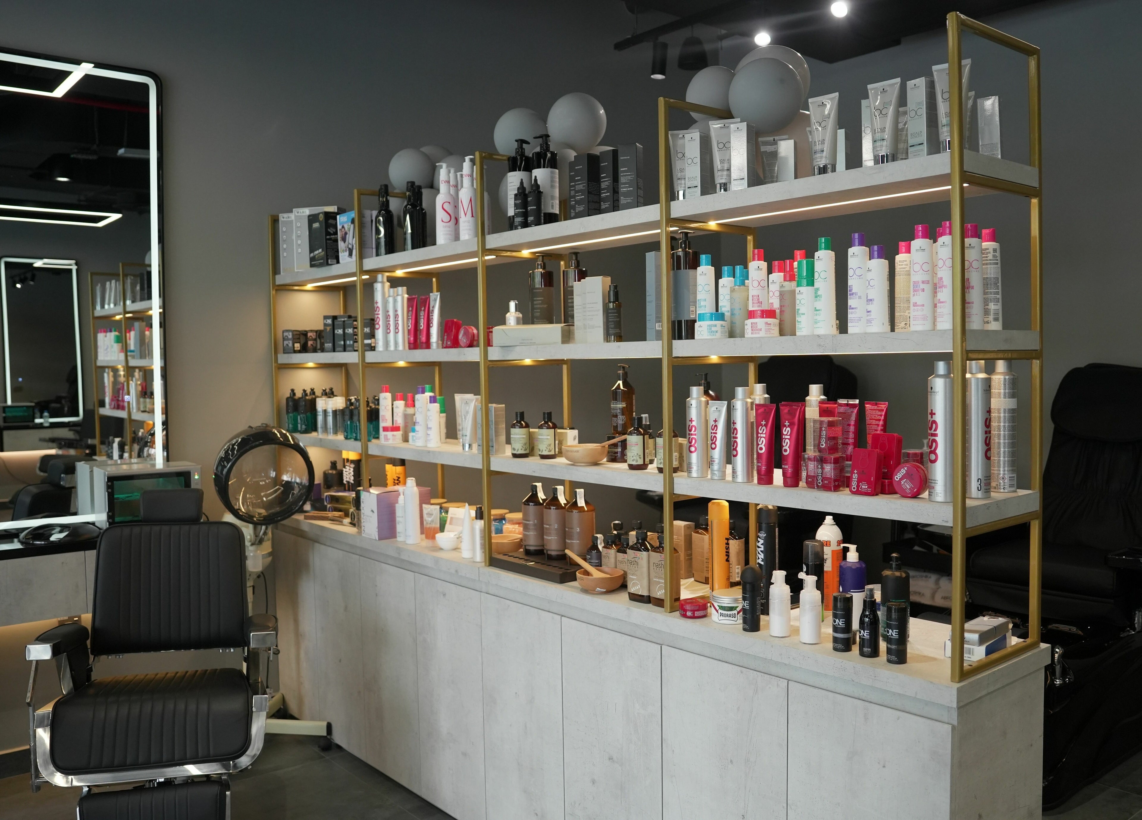 Product shelves and styling chair at Abroshka Gents Salon, Dubai, AE, showcasing salon essentials.
