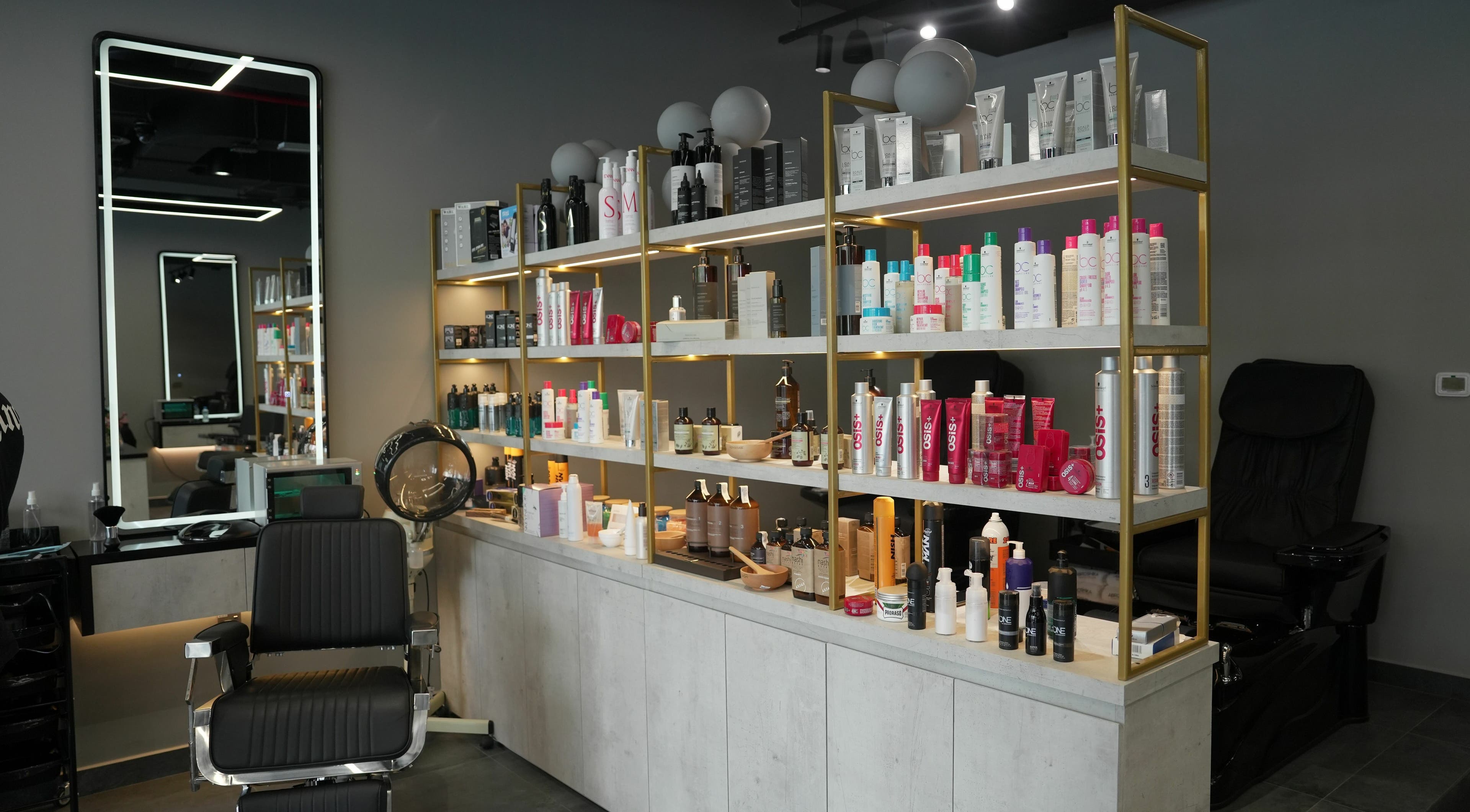 Product shelves and styling chair at Abroshka Gents Salon, Dubai, AE, showcasing salon essentials.