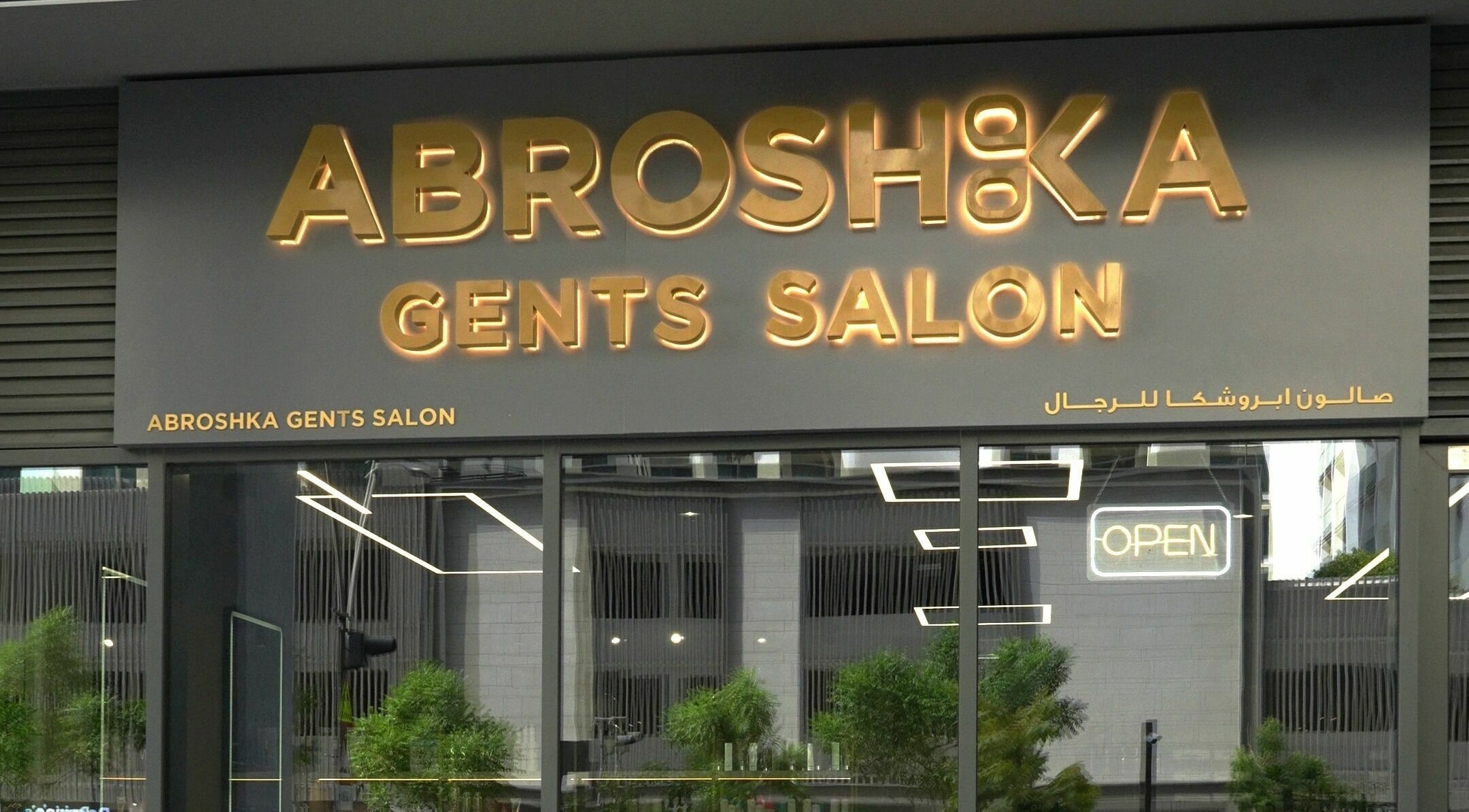 Entrance of Abroshka Gents Salon in Dubai, AE with glowing signage.
