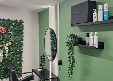 Elegant salon setup at Hair by Teri, Wishaw, Scotland, GB with lush greenery and stylish shelves.