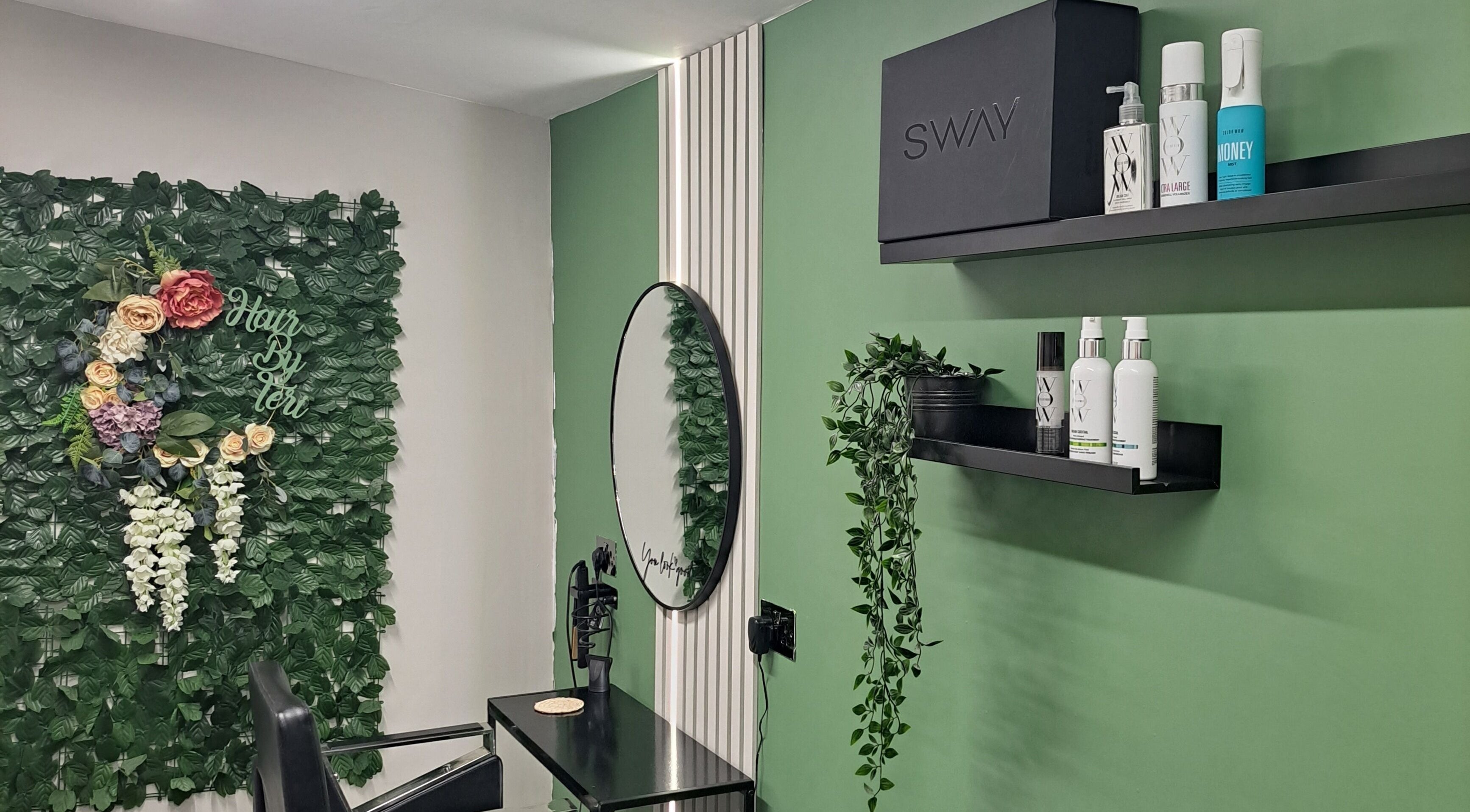 Elegant salon setup at Hair by Teri, Wishaw, Scotland, GB with lush greenery and stylish shelves.