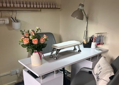Elegant nail station at Roots Hair & Co in Needham Market, England, GB, featuring floral decor and organized tools.