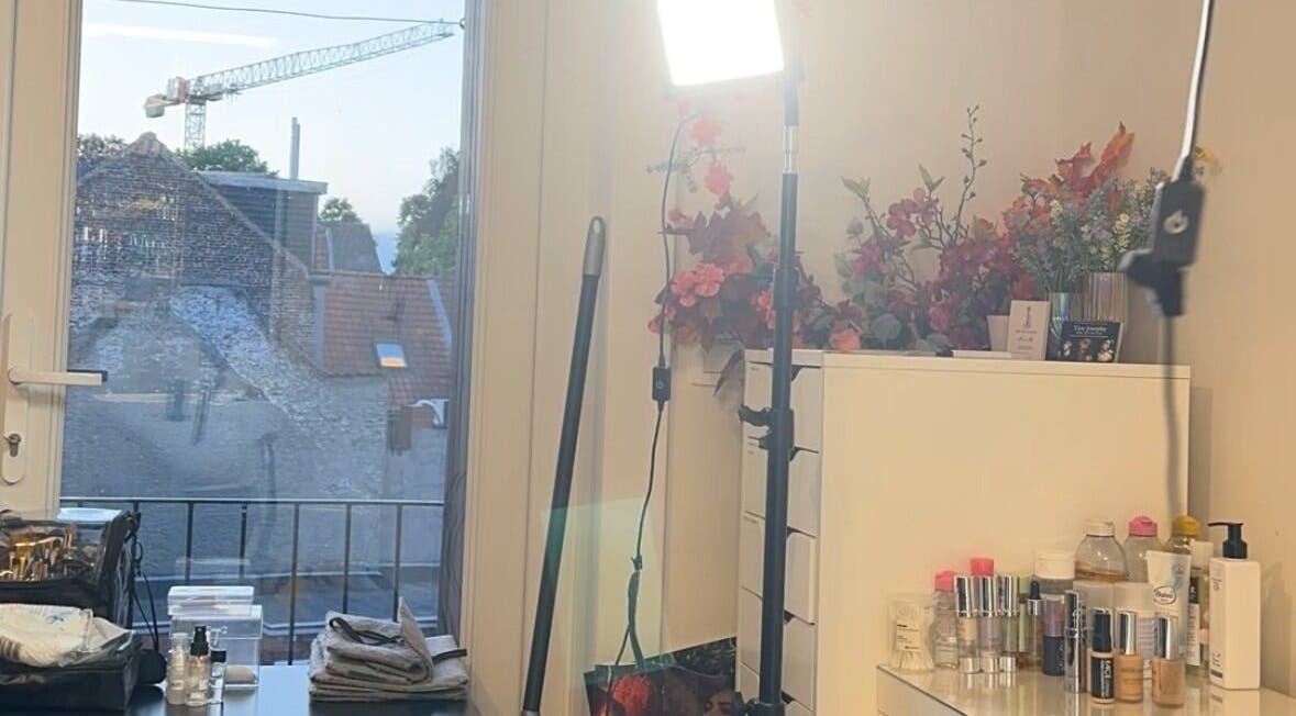 Studio Tinka by Tine Josephy in Gent, Vlaams Gewest, BE. Makeup setup with bright lighting and floral decor.