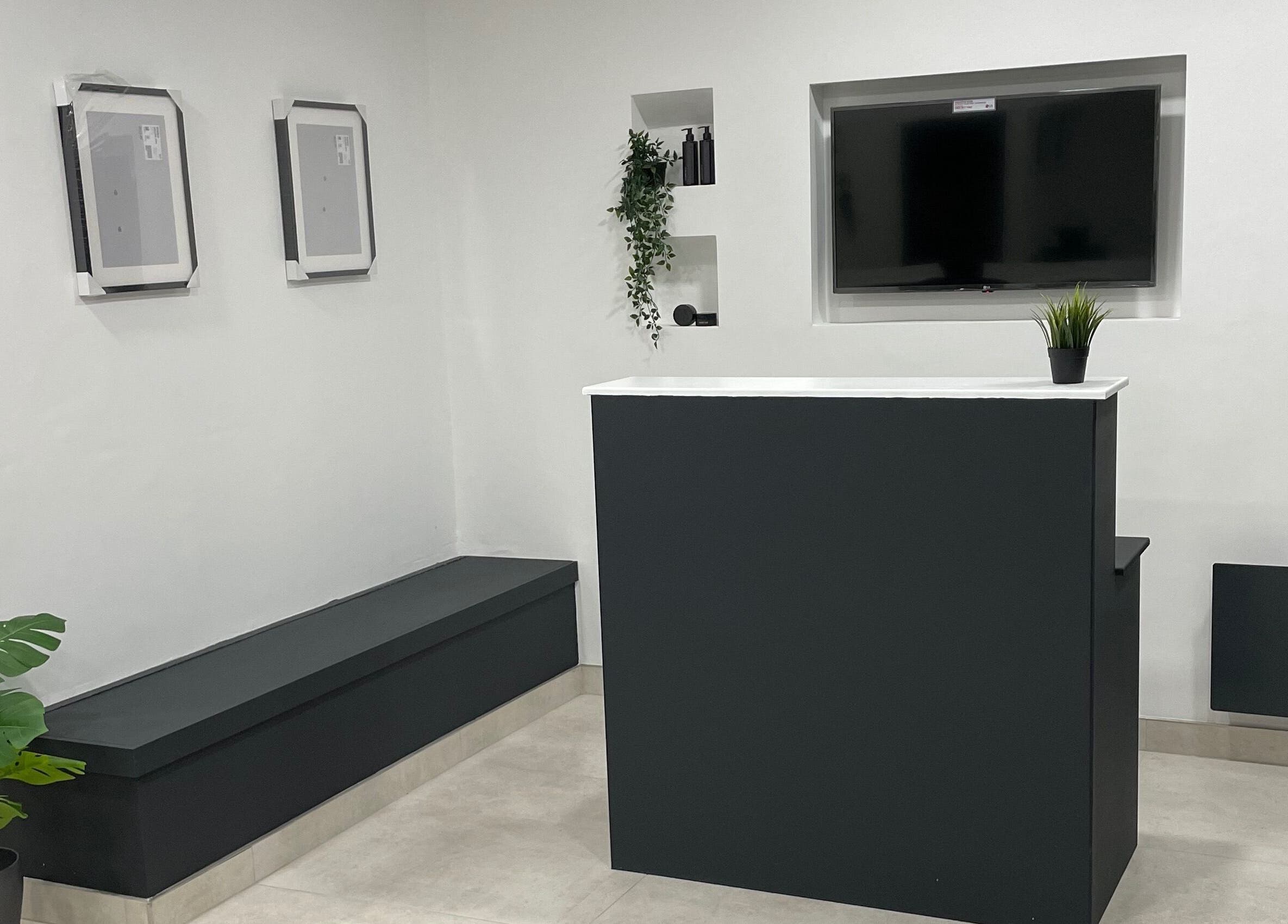 Reception area at Club Twenty Two, Cardiff, Wales, GB showcasing modern design with sleek counters and greenery.