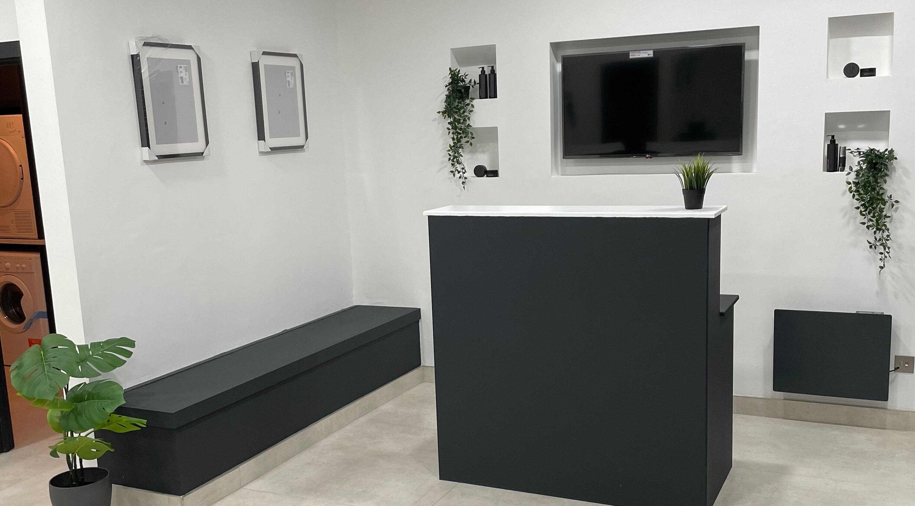 Reception area at Club Twenty Two, Cardiff, Wales, GB showcasing modern design with sleek counters and greenery.