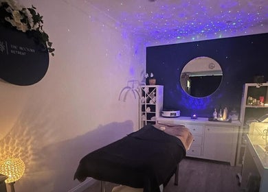 Relaxing spa room at The Rectory Retreat, Rochford, England, GB, featuring cozy lighting and a treatment bed.