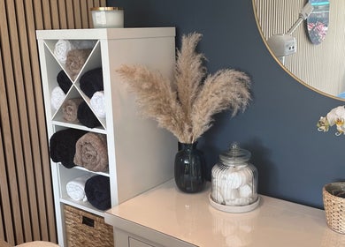 Elegant decor at The Rectory Retreat, Rochford, England, with towels, vase, and orchid on display.