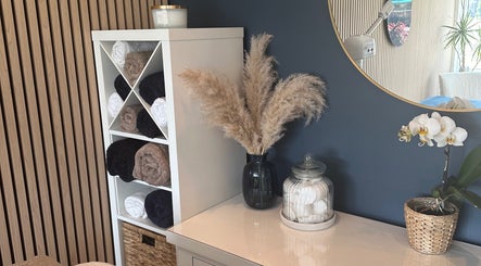 Elegant decor at The Rectory Retreat, Rochford, England, with towels, vase, and orchid on display.