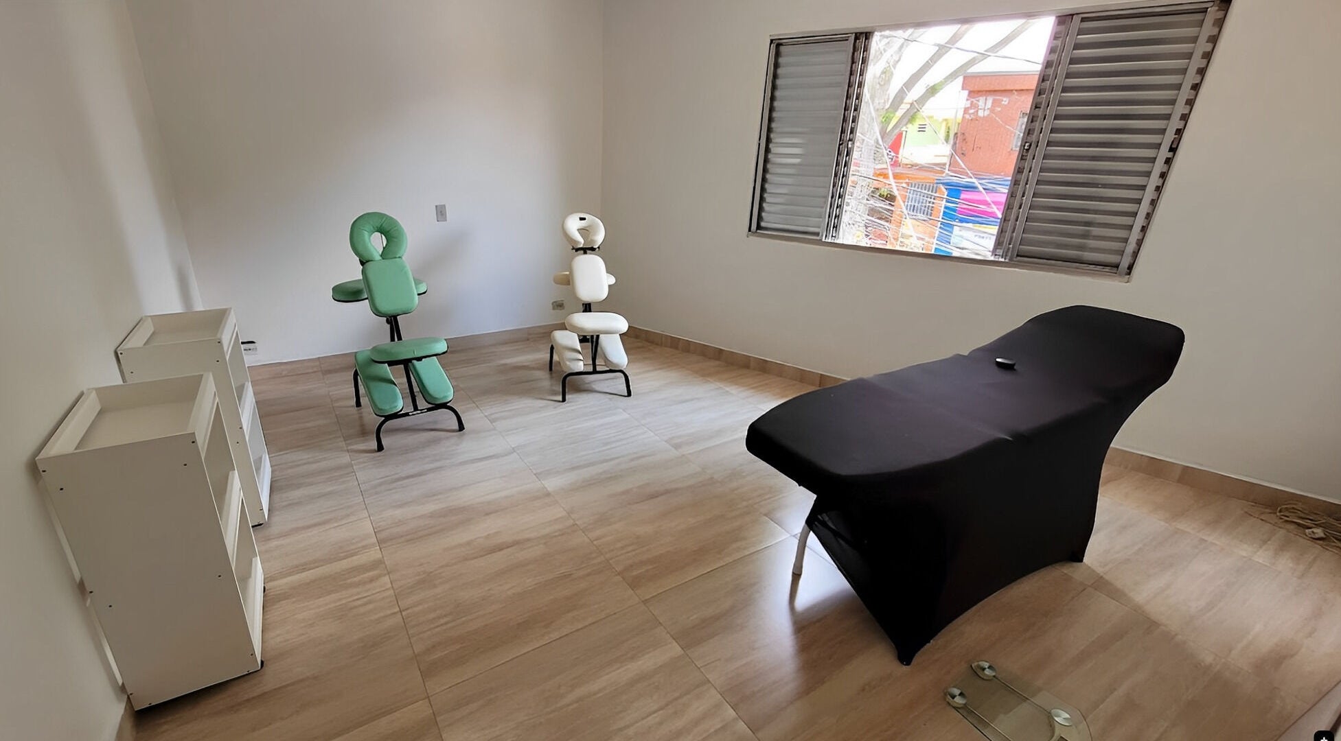 Sala de massagem com cadeiras e maca em Espaço Tsugawa Massagens, Estética e Bem Estar, São Paulo, São Paulo, BR.