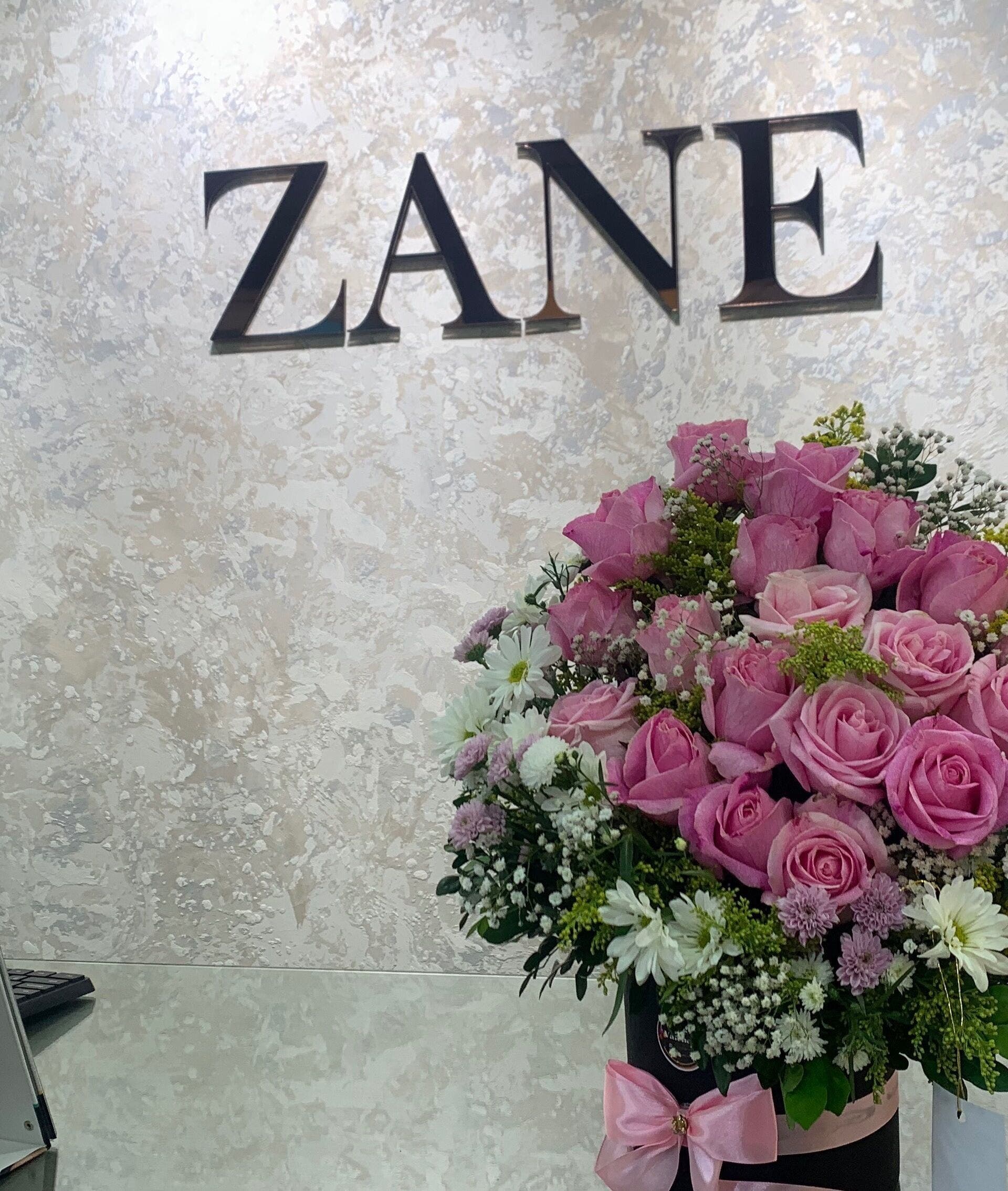 Arreglo de rosas frente al logo Zane en Valencia, Carabobo, VE. Escaparate y muestra de esmaltes.