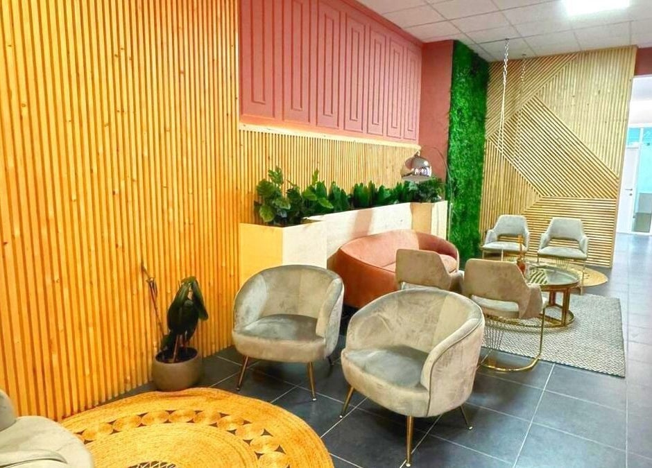 Intérieur élégant d'Atelier Rafaela Ferreira à Uccle, Bruxelles, BE avec fauteuils modernes et mur végétal.