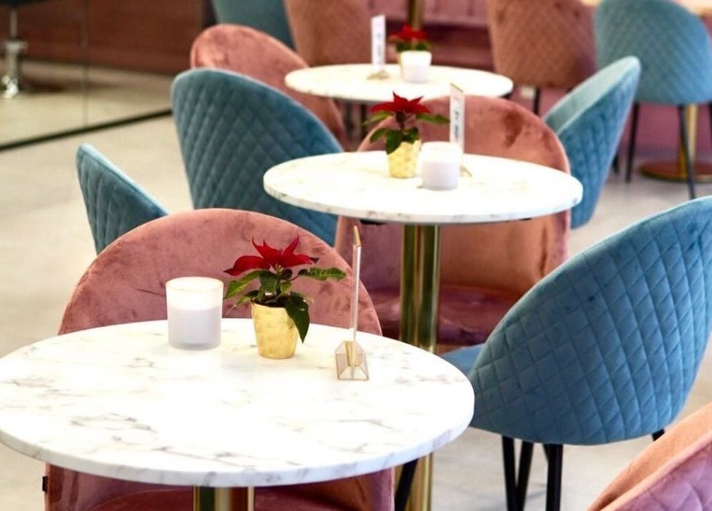 Intérieur raffiné chez Atelier Rafaela Ferreira à Uccle, Bruxelles, BE avec chaises colorées et tables marbrées.