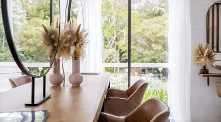 Bright, elegant interior of Edge Hairdressing at Tamborine Mountain, QLD with chic decor and lush greenery outside.