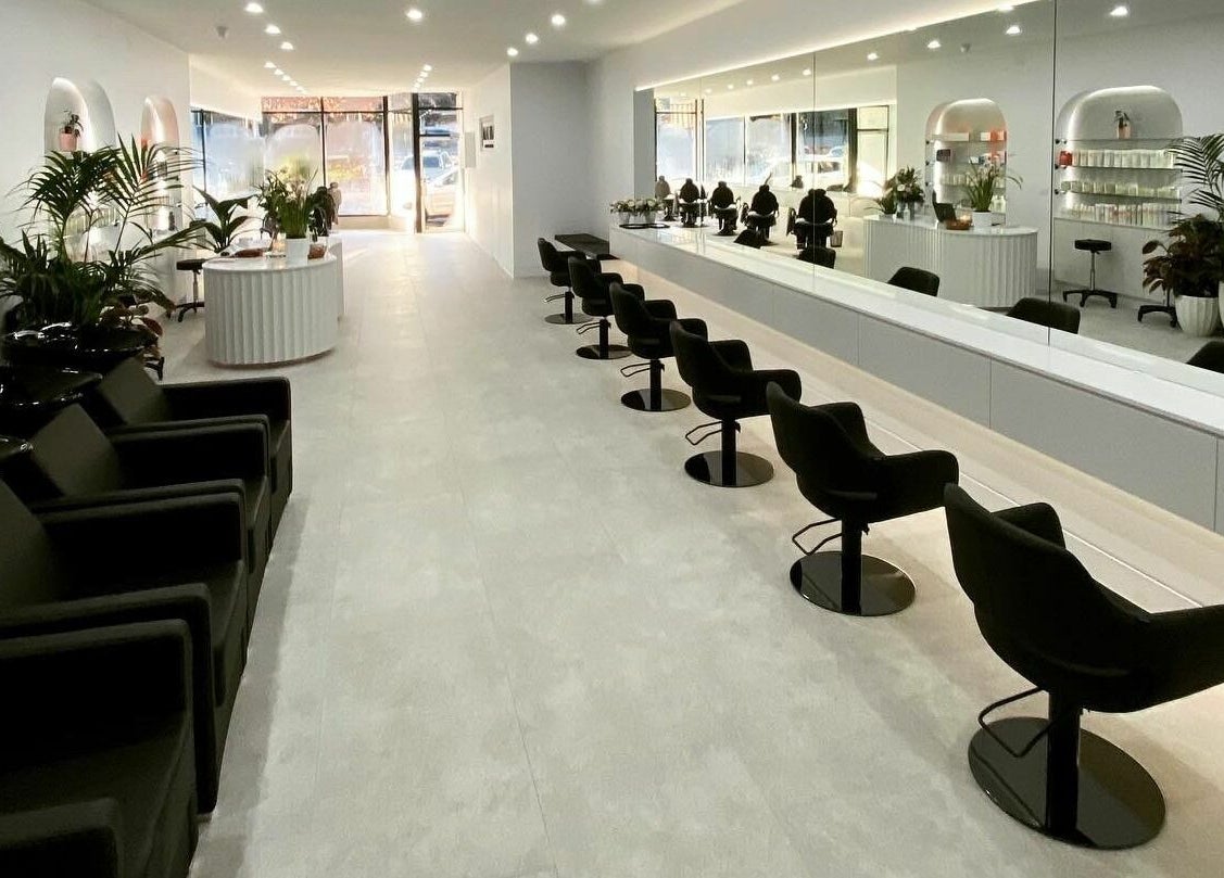 Bright, modern interior at Maliha Salon And Barber in Melbourne, Victoria, AU showcasing stylish black chairs and mirrors.