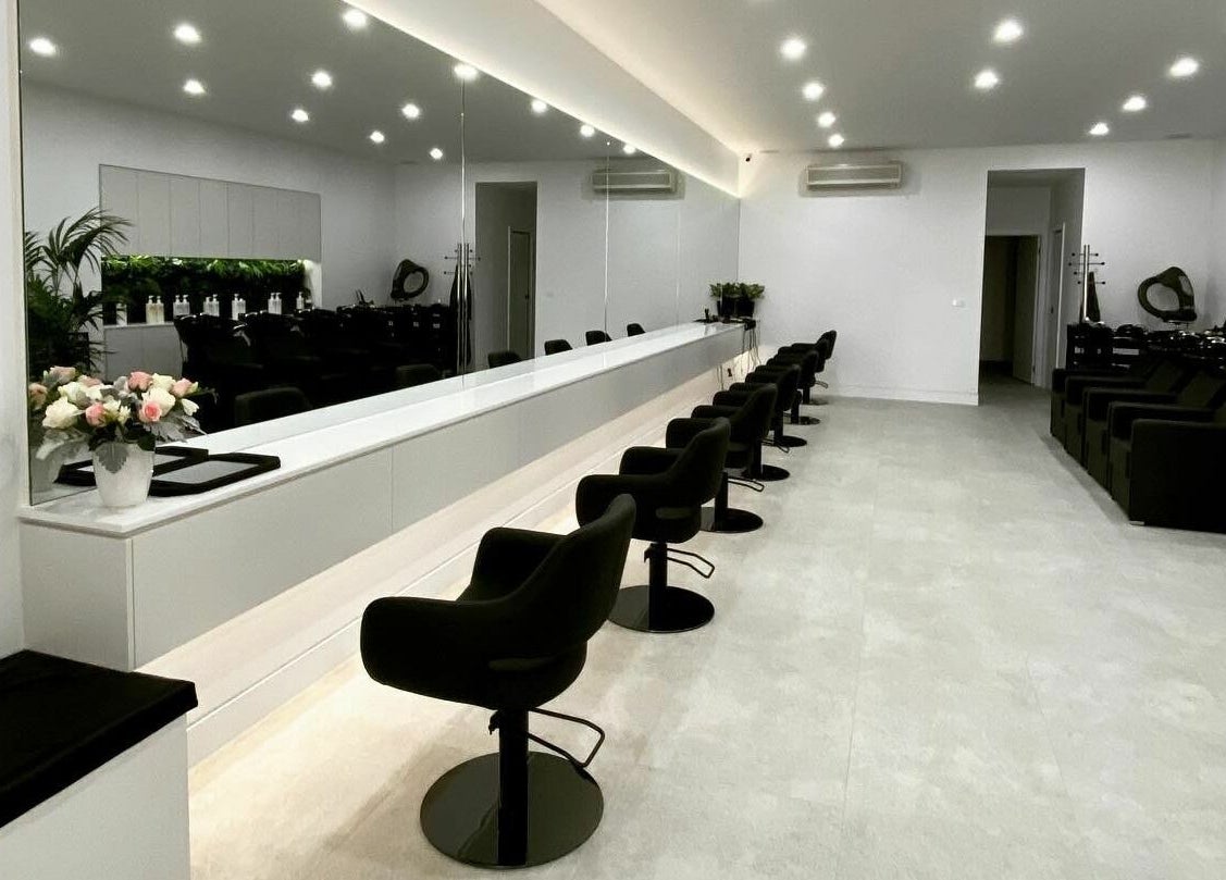 Modern, elegant interior of Maliha Salon And Barber in Melbourne, Victoria, AU with sleek chairs and mirrors.
