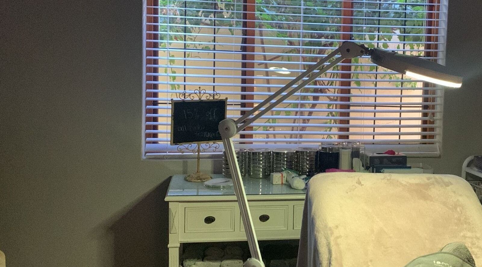 Calm treatment area at Moi Moi Paarl in Paarl, Western Cape, ZA, featuring a bed, lamp, and natural light.