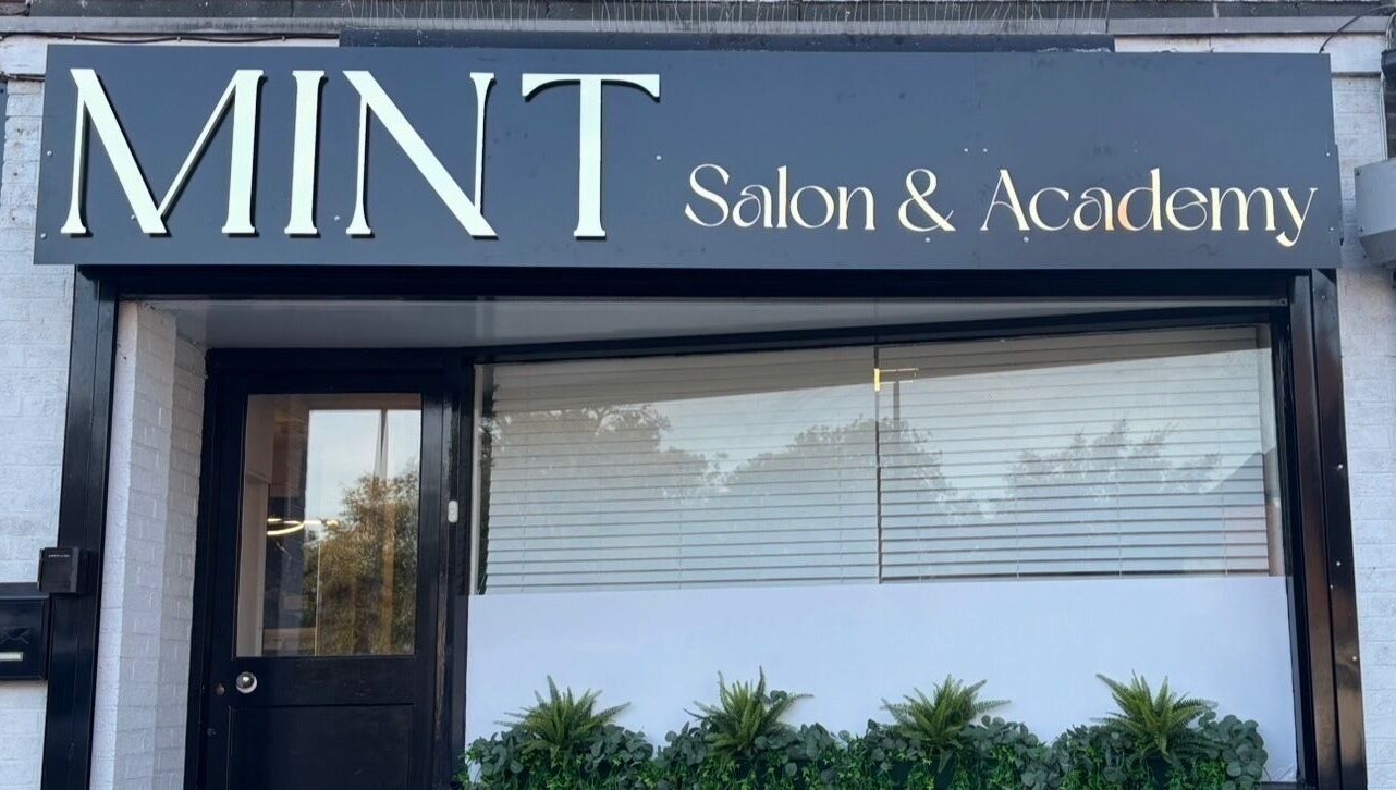 Front view of Mint Salon & Academy, Derby, England, GB, showcasing sleek modern signage and window decor.