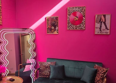 Bright pink lounge with chic decor at Shepack Beauty, Paignton, England, GB. Modern mirror and stylish art.