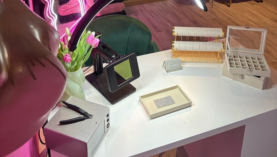 Elegant jewelry display at Shepack Beauty, Paignton, England, GB with pink tulips on a white desk.