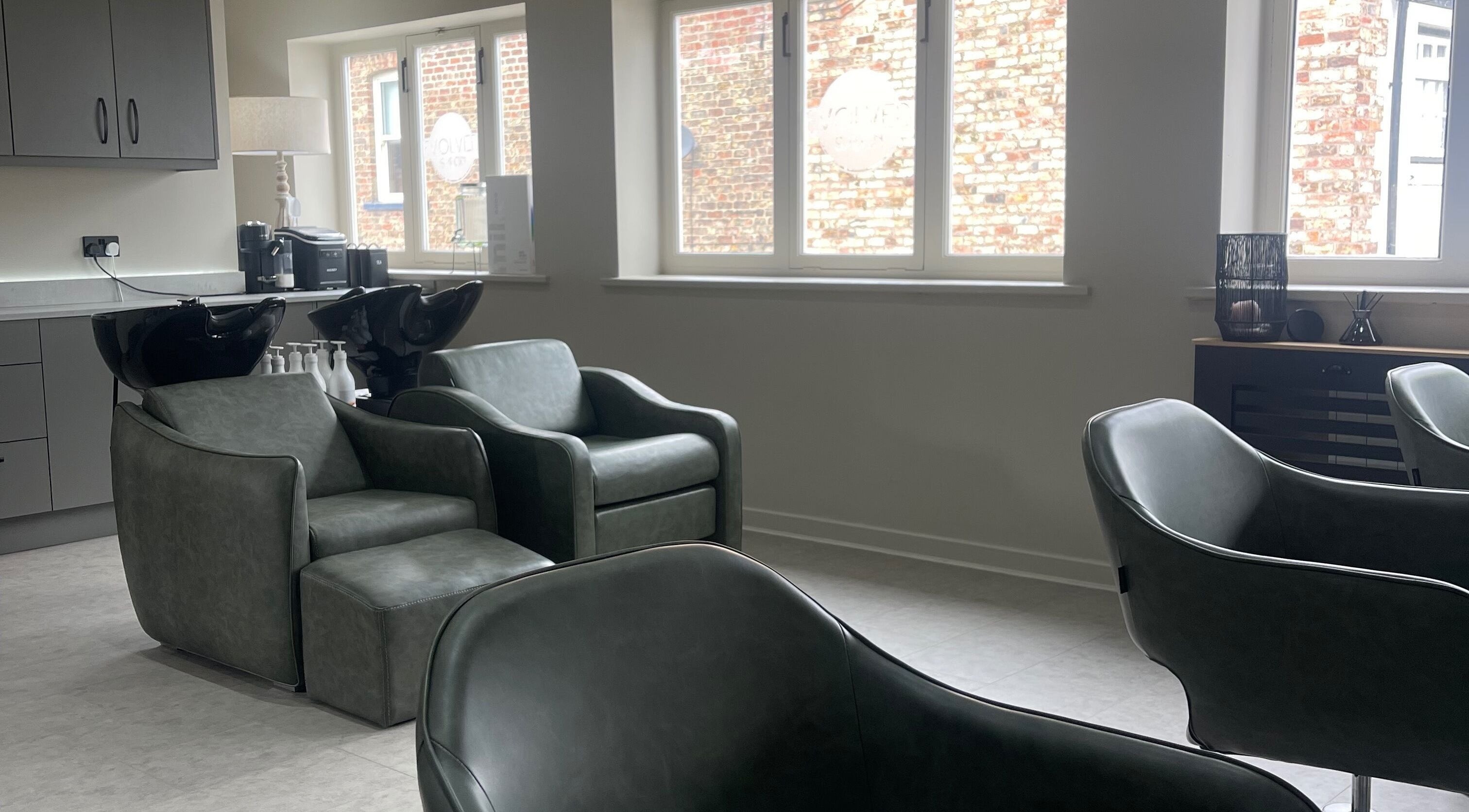 Modern salon chairs and basins at Evolved Salon, Boroughbridge, England, GB, showcasing stylish interior design.