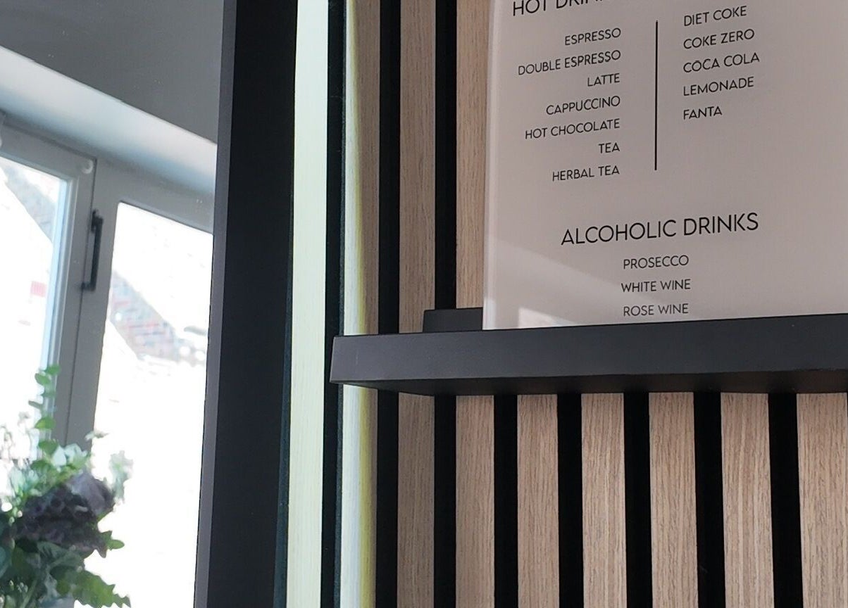 Beverage menu at Evolved Salon in Boroughbridge, England, showcasing hot and alcoholic drinks.