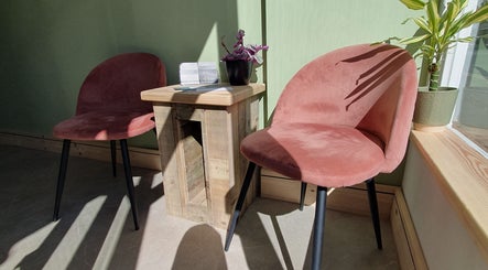 Cozy seating area at CK Laser at Salon Forty Four, Eastbourne, England, GB with stylish pink chairs and decor.