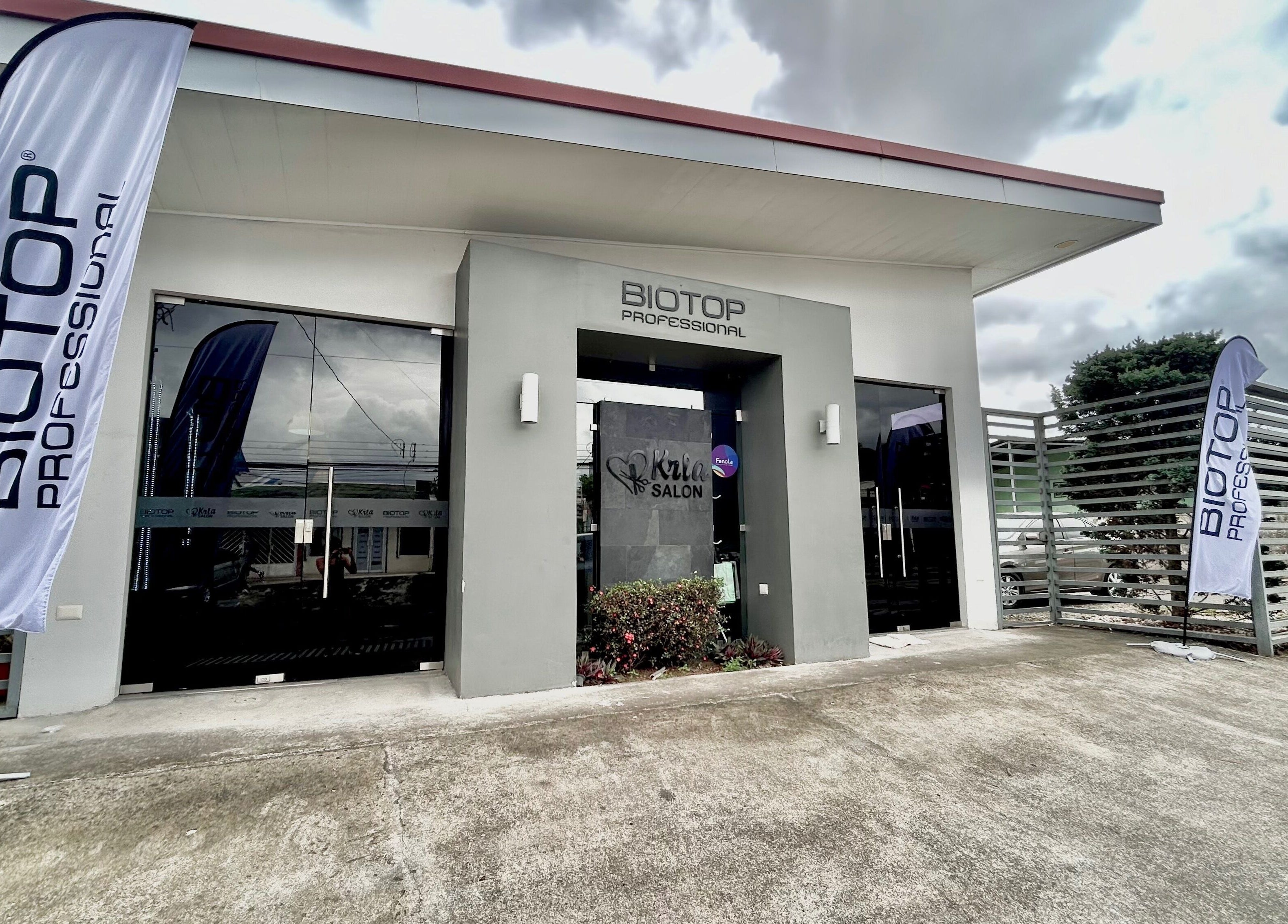 Entrada moderna de Krla Salon en Guápiles, Limón, CR con banderas de Biotop.