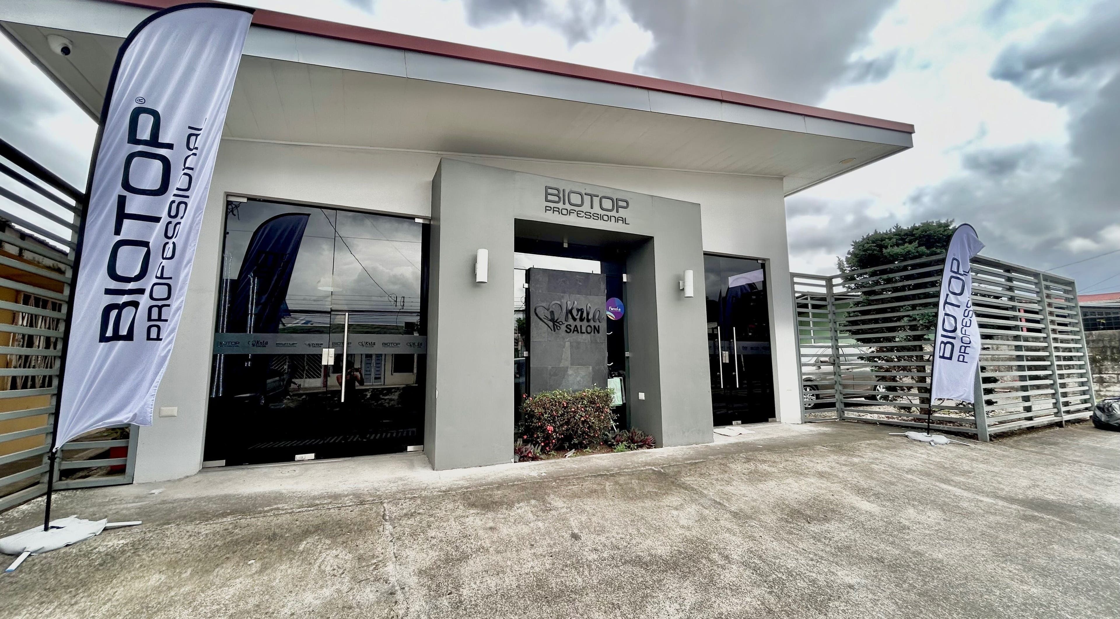 Entrada moderna de Krla Salon en Guápiles, Limón, CR con banderas de Biotop.
