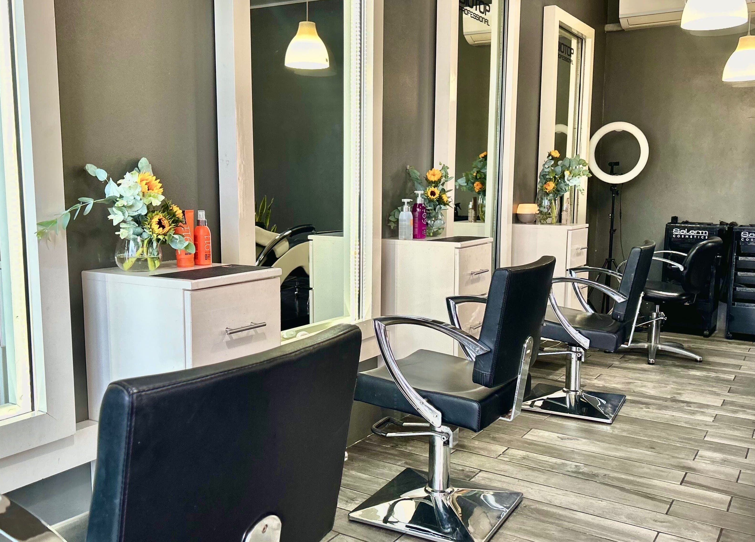 Interior moderno de Krla Salon en Guápiles, Limón, CR con sillas elegantes y arreglos florales.