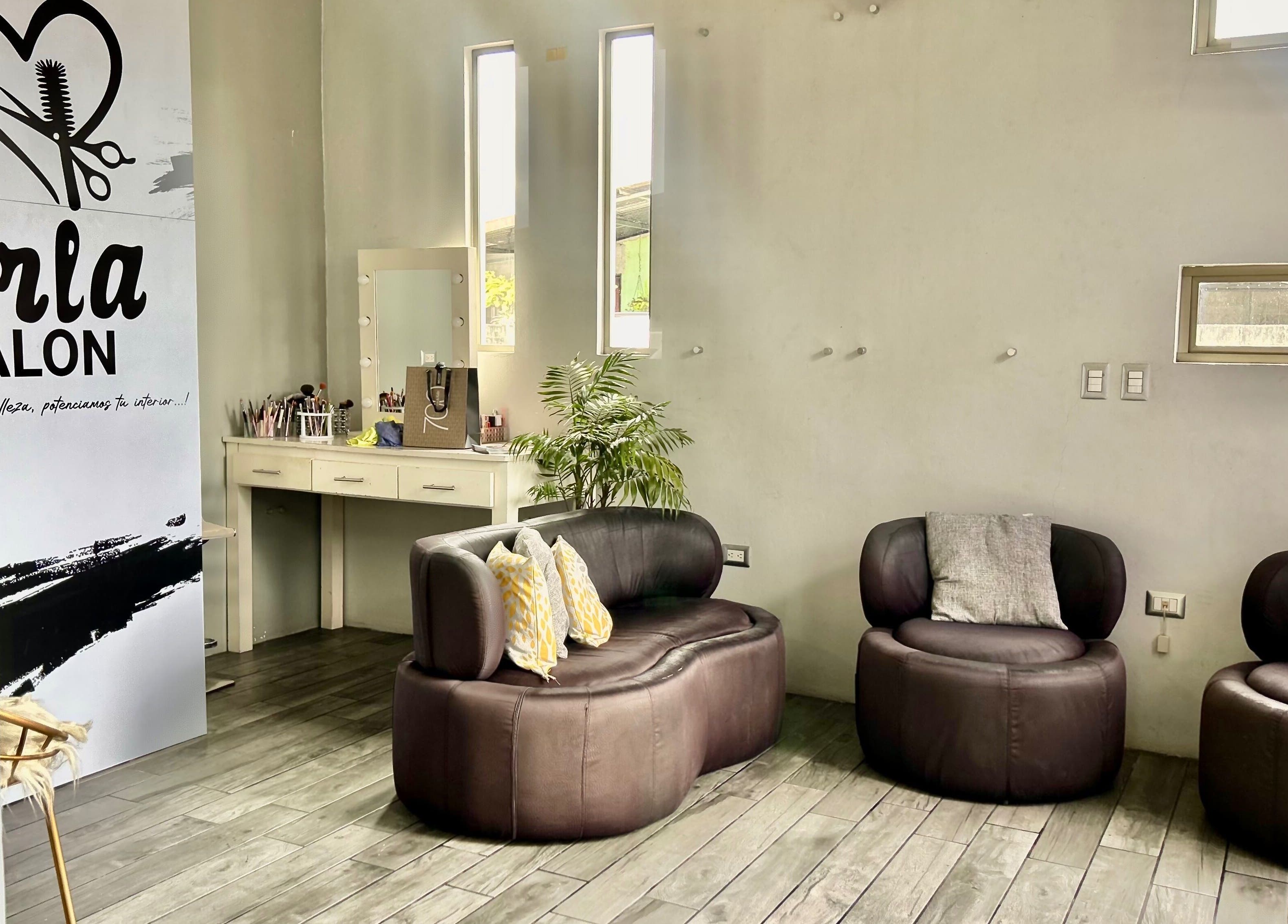 Sala de espera elegante en Krla Salon, Guápiles, Limón, CR, con asientos de cuero y decoración moderna.