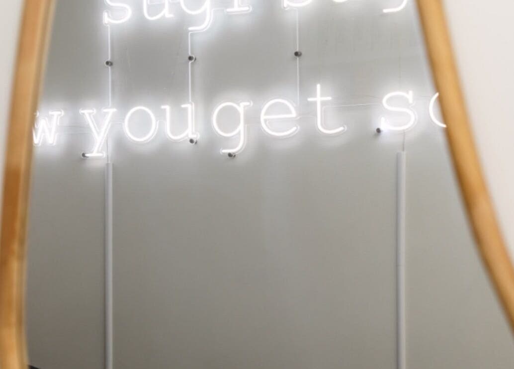 Neon sign reflection in mirror at Sugr Sugr Wax Bar, Ottawa, Ontario, CA. Chic atmosphere captured elegantly.