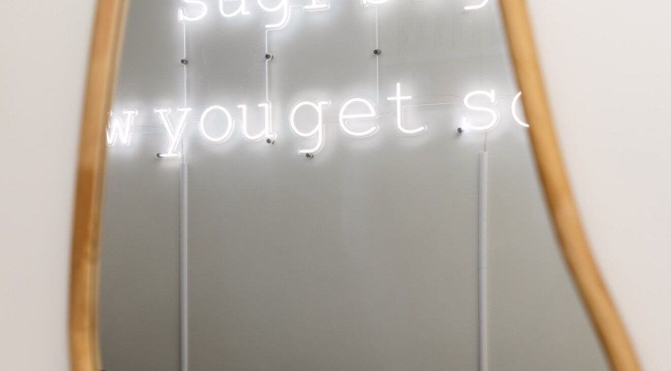 Neon sign reflection in mirror at Sugr Sugr Wax Bar, Ottawa, Ontario, CA. Chic atmosphere captured elegantly.