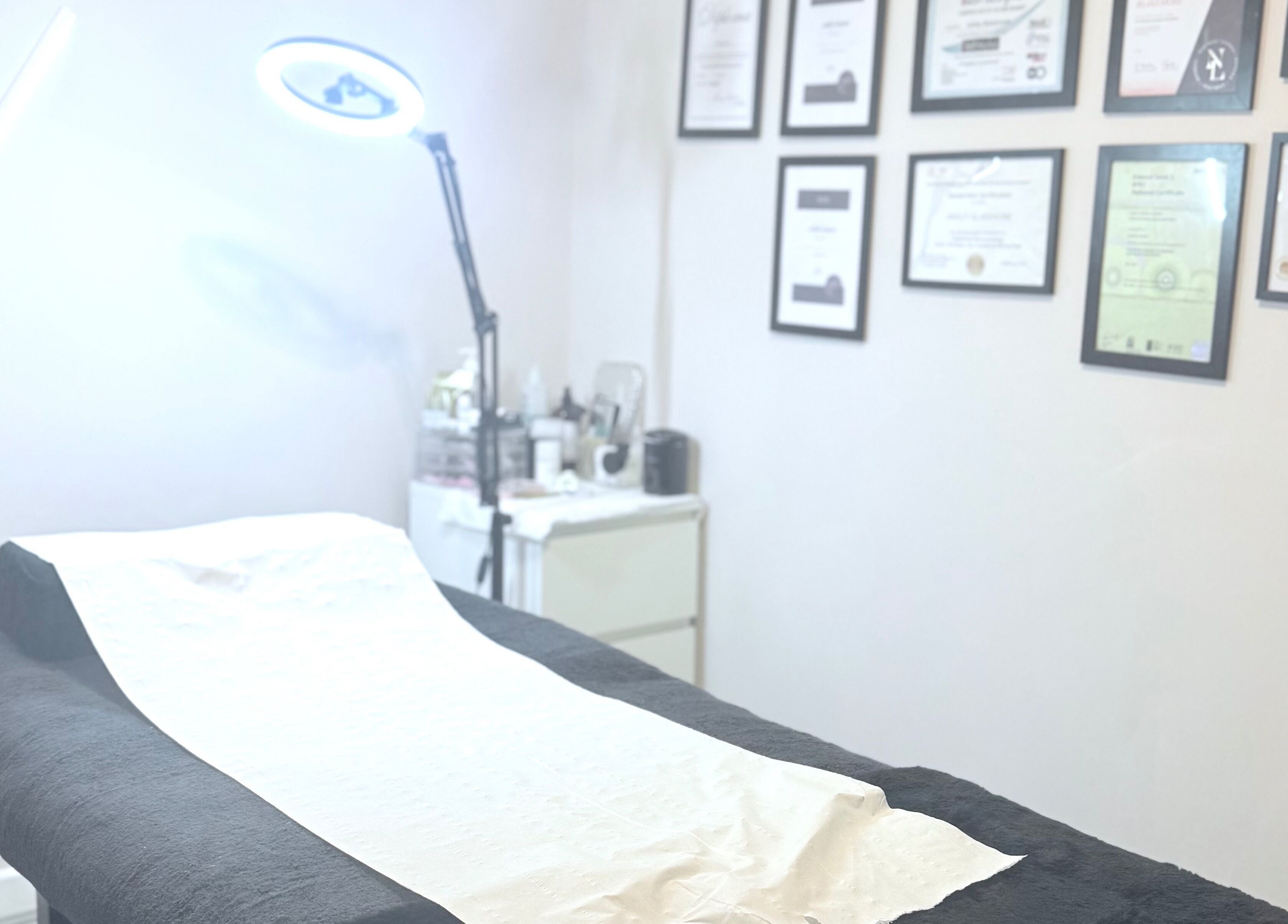 Cozy treatment room at Ashley Blakemore Beauty & PMU in Cheadle, England, GB with certificates on the wall.