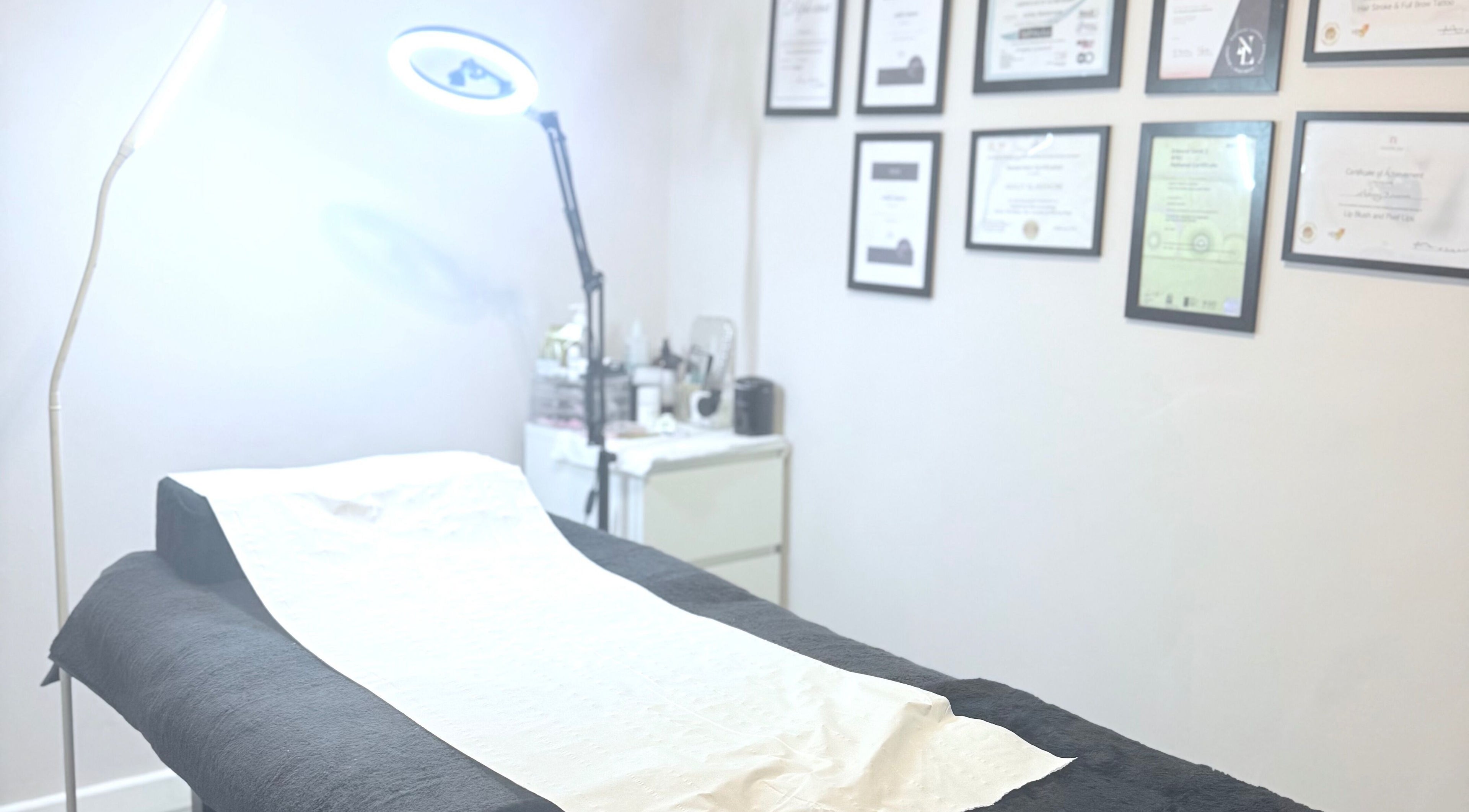 Cozy treatment room at Ashley Blakemore Beauty & PMU in Cheadle, England, GB with certificates on the wall.