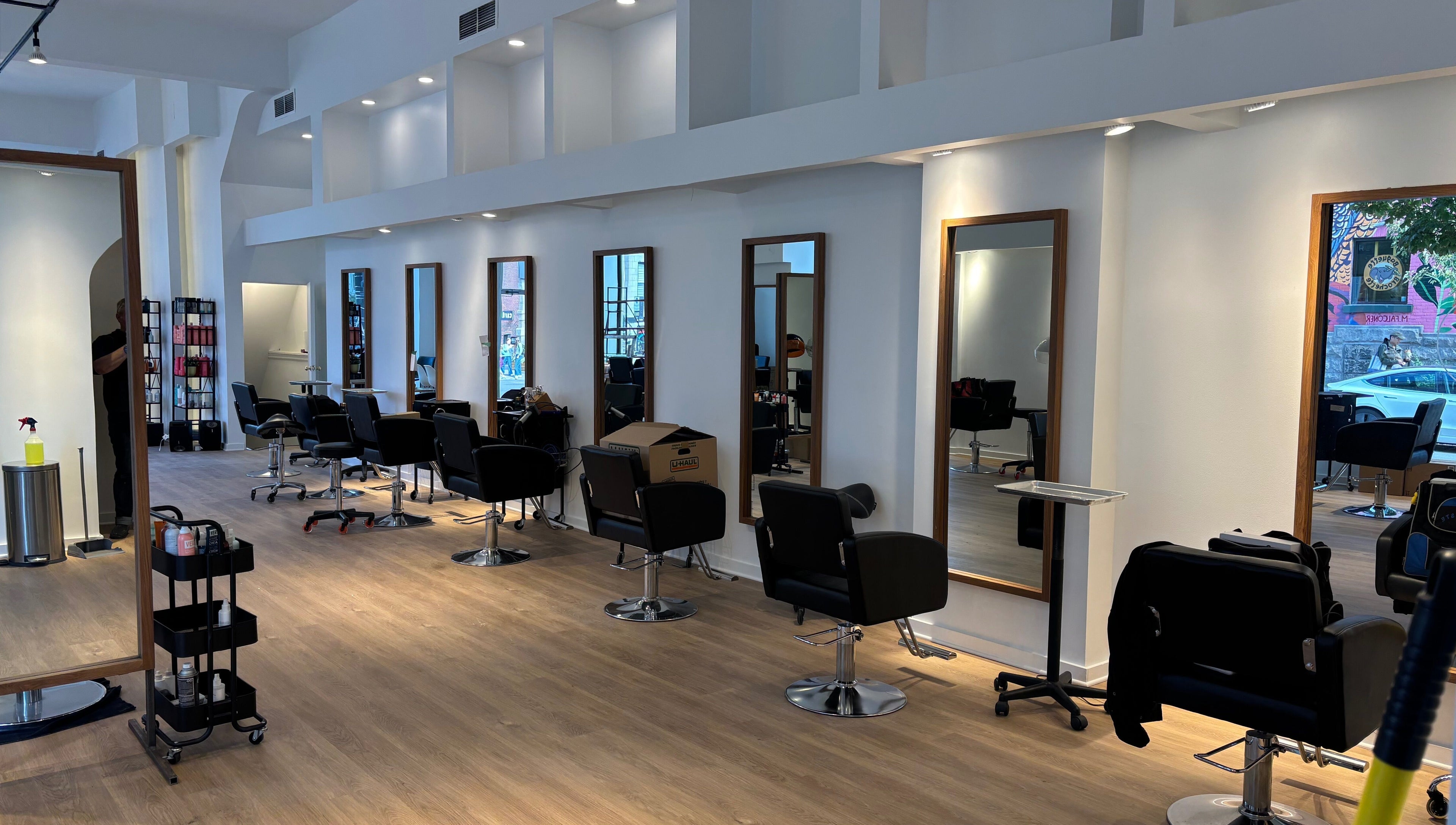 Intérieur moderne du salon Ka Coiffure à Montréal, Québec, CA avec stations de coiffure chic.