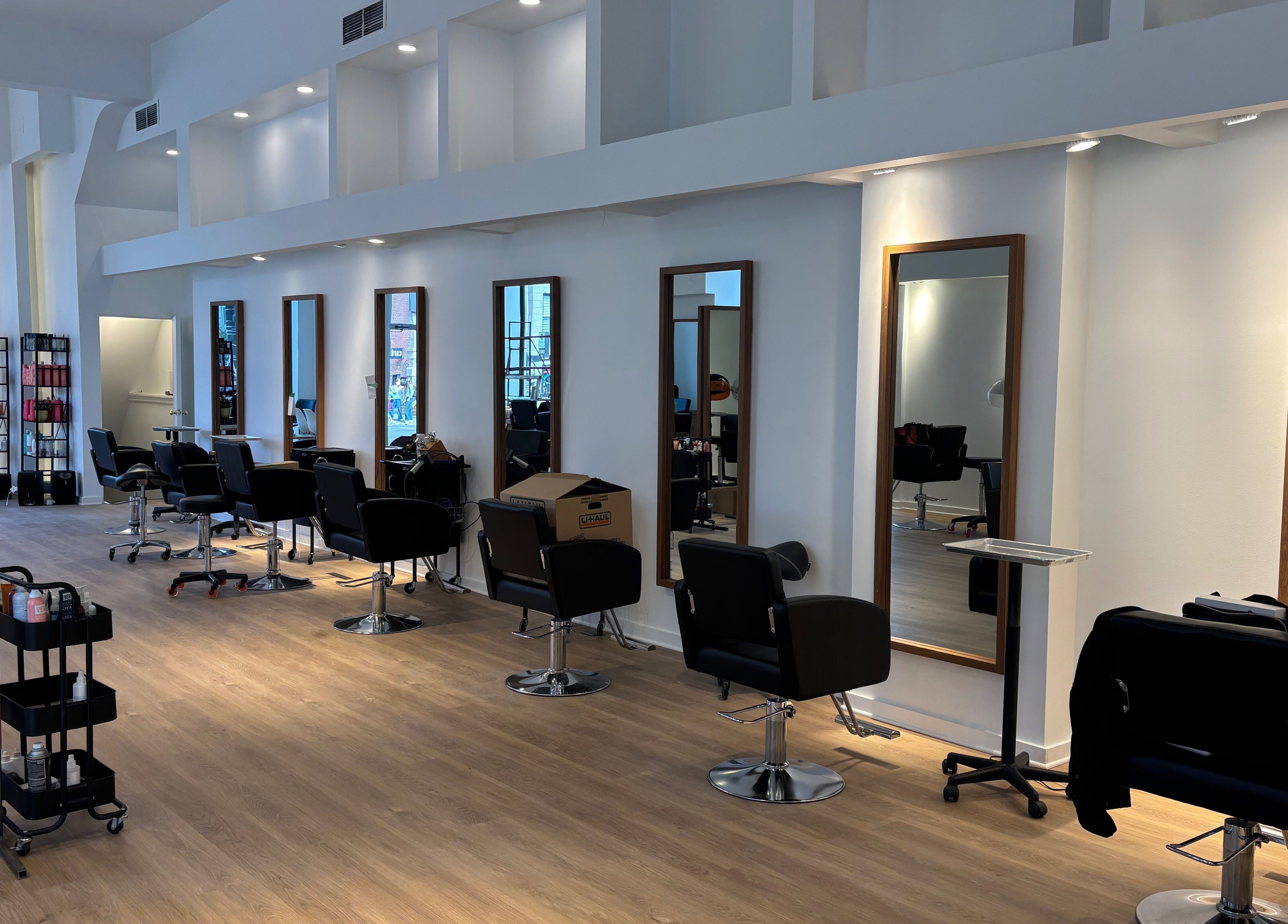 Intérieur moderne du salon Ka Coiffure à Montréal, Québec, CA avec stations de coiffure chic.