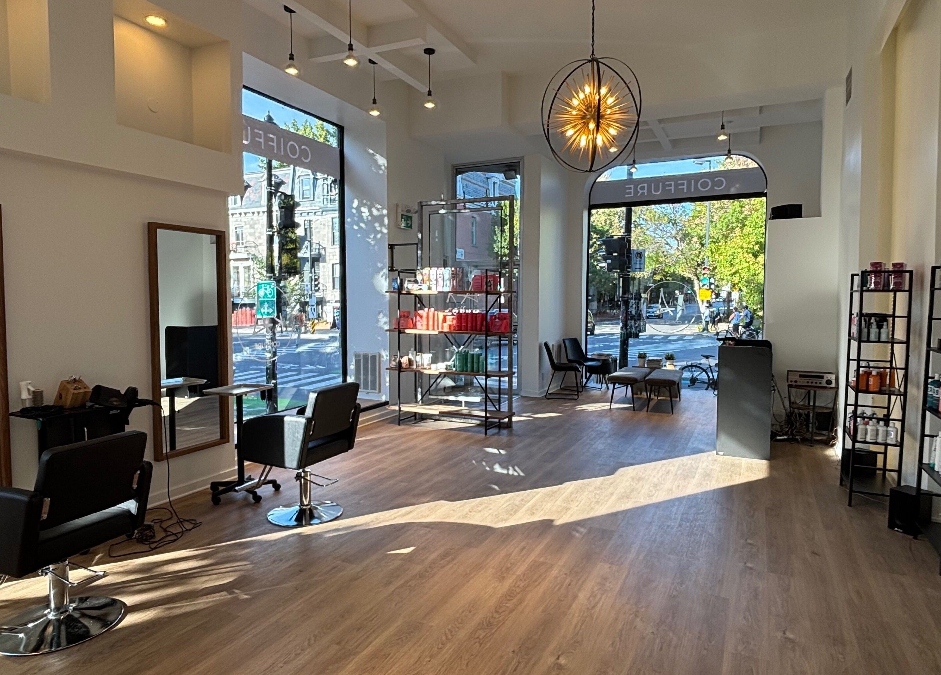 Intérieur lumineux de Ka Coiffure à Montréal, Québec, CA, avec sièges élégants et produits de beauté.