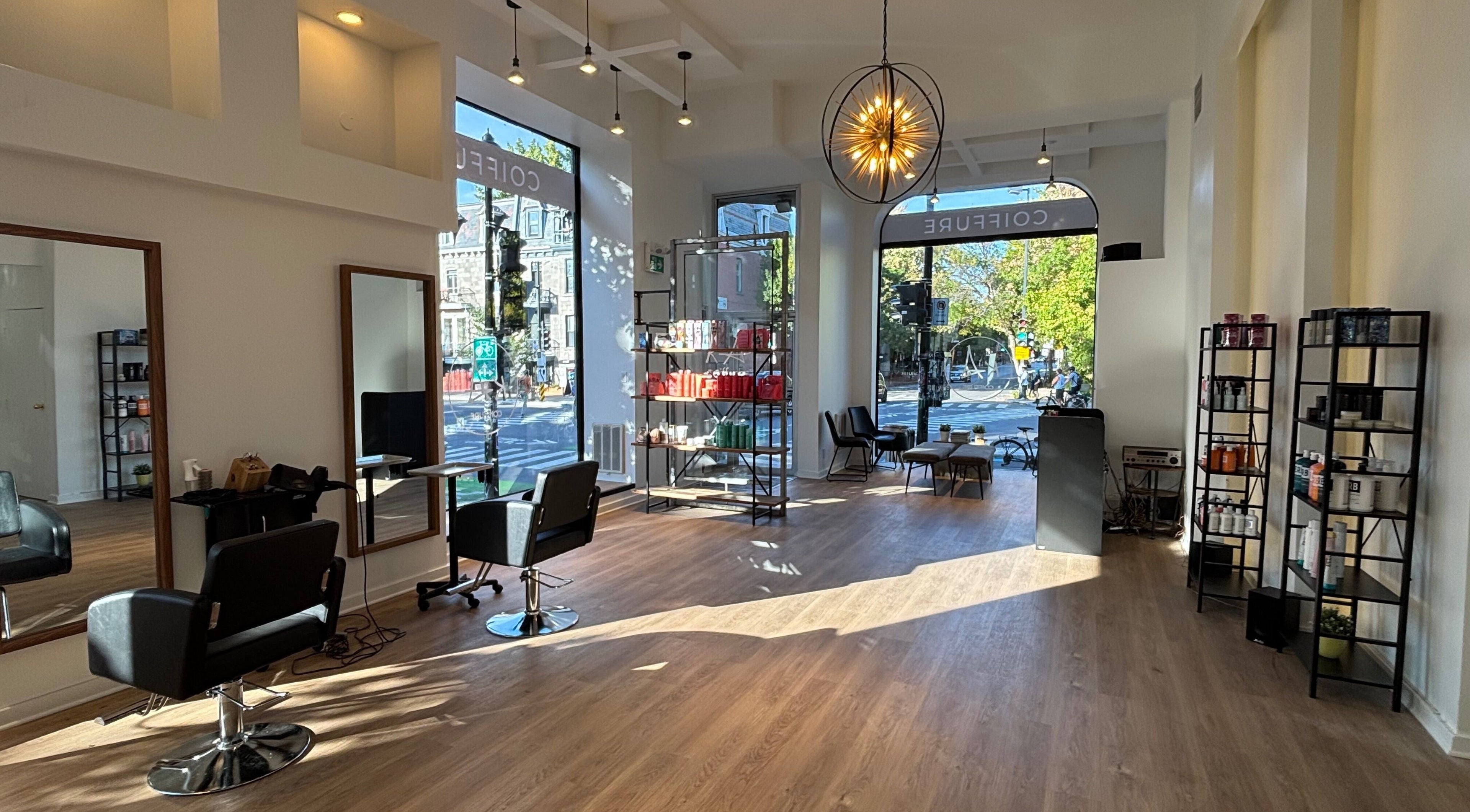 Intérieur lumineux de Ka Coiffure à Montréal, Québec, CA, avec sièges élégants et produits de beauté.