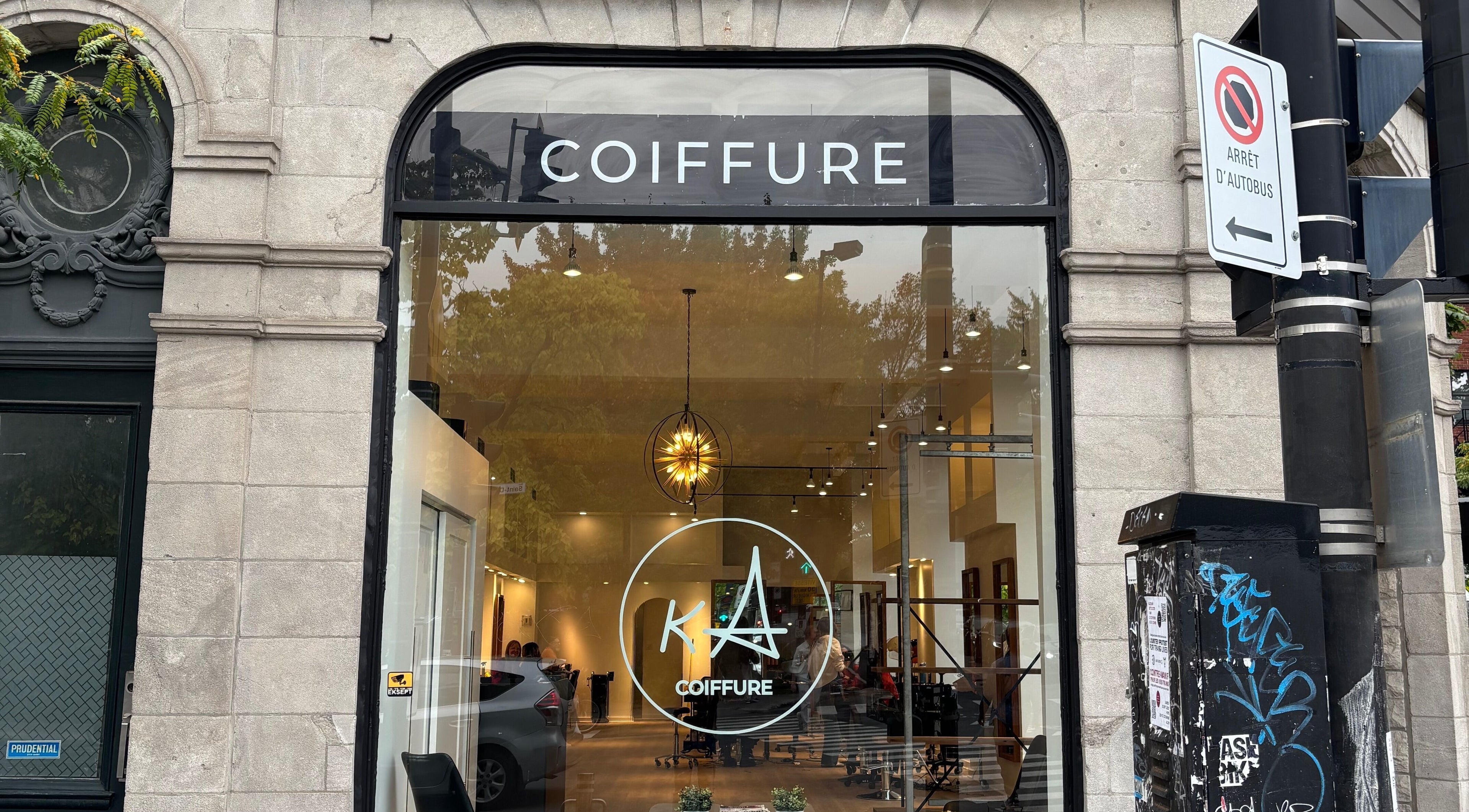 Façade de Ka Coiffure à Montréal, Québec, CA, mettant en valeur son élégant intérieur lumineux.