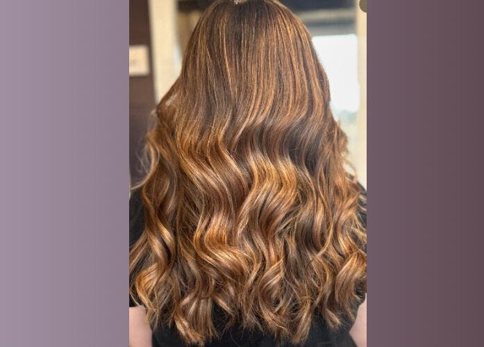 Styled wavy hair with golden highlights at Five One Four, Littlehampton, England, GB.