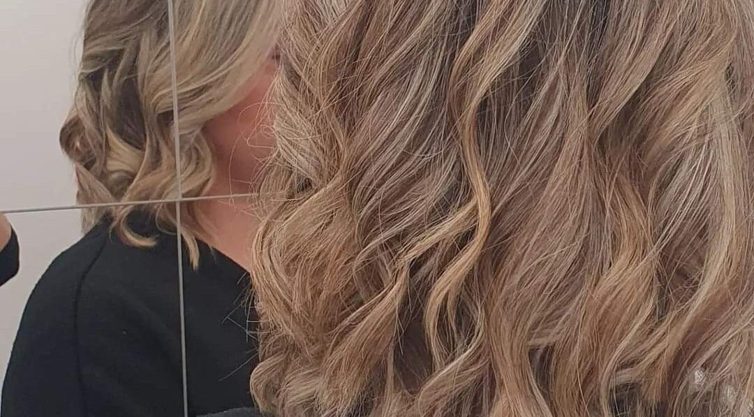 Blonde curls styled at ES Collective, Hornchurch, England, GB, reflected in the mirror.
