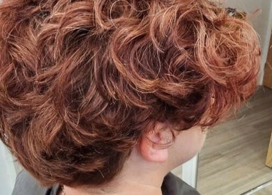 Curly hairstyle at ES Collective, Hornchurch, England, GB, showcasing voluminous red curls.
