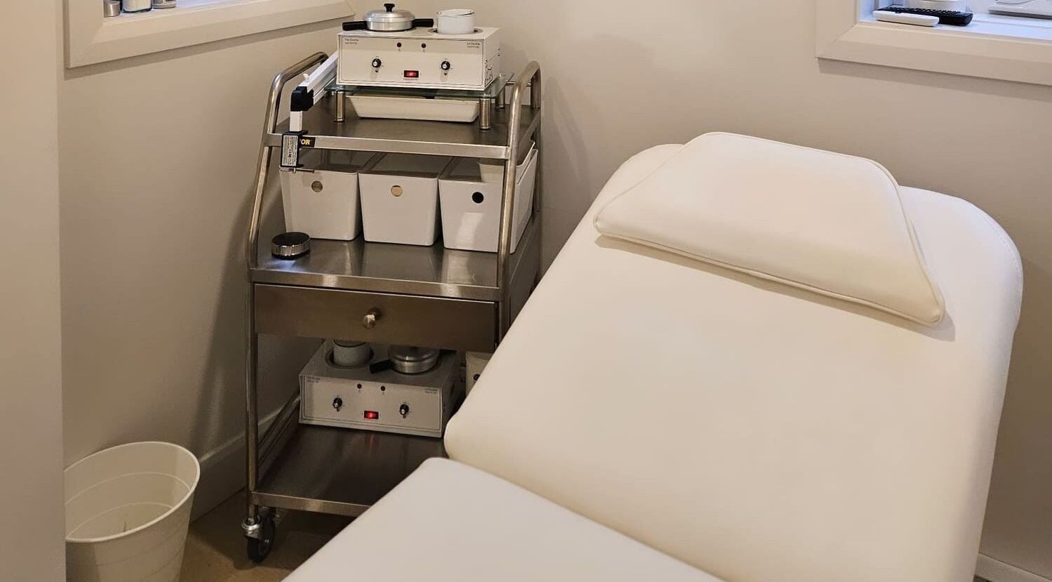 Cozy waxing room at L.F Waxing in Montreal, Québec, CA, showcasing a treatment bed and equipment.