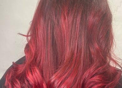 Vibrant red wavy hairstyle at Cove Hair Beauty Wellness in Padstow, England, GB.