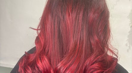 Vibrant red wavy hairstyle at Cove Hair Beauty Wellness in Padstow, England, GB.